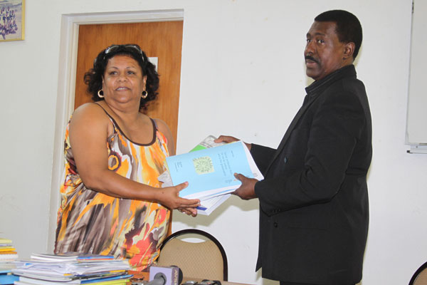 WICLU Vice President Claire Elshot handing over books from ILO to President of WICLU Theophillus Thompson. celshotpresentingbookstotthompson12072012