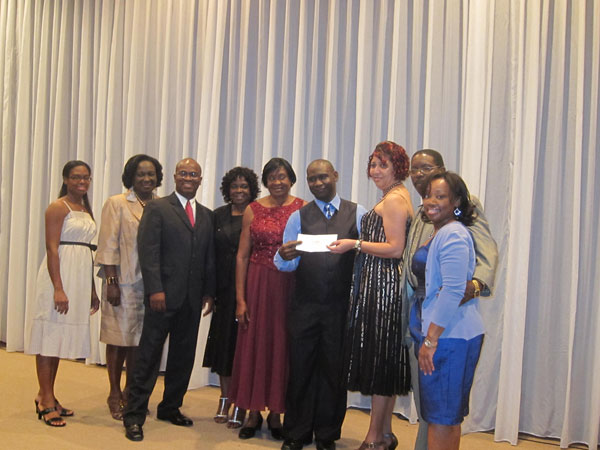 Paul Emmanuel presents donation to Treasurer Margarette Williams surrounded by JFE boardmembers, keynote speaker Patricia Lourens, and Fernando Clarke. jfedinner29012012