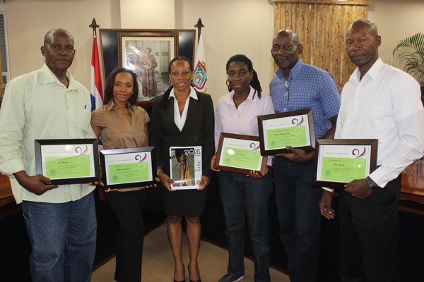 Minister Rhoda Arrindell (center, holding the draft sports policy) flanked by members of the Technical Committee, with their Certificates of Appreciation. (DCOMM Photo) rarrindellreceivesdraftsportspolicy07052012