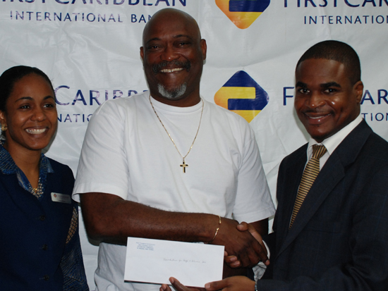Don Froston receiving donation from First Caribbean Bank representative. don_frostonjan_2009_donation_fcib006