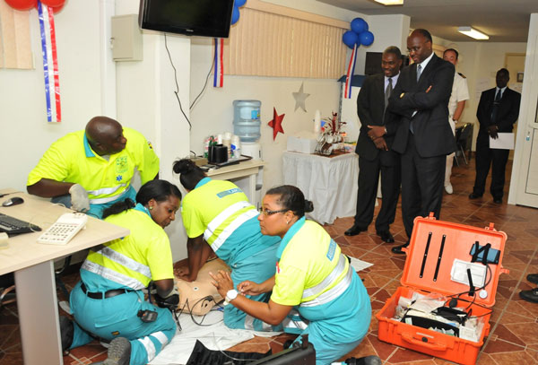 Left to right, Ambulance personnel in action as Head of the Ambulance Dept. drs. Cylred Richardson and HE Governor Holiday look on. (DCOMM Photo) eholidayvisitsambulancedept15092011