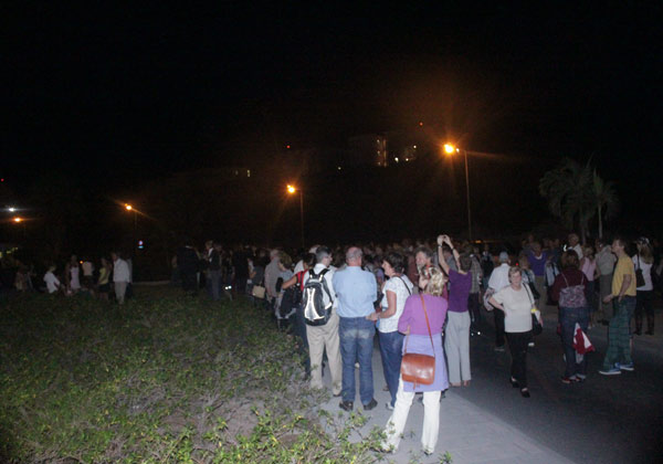 Passengers standing alongside the road and parking lot. pass19022010