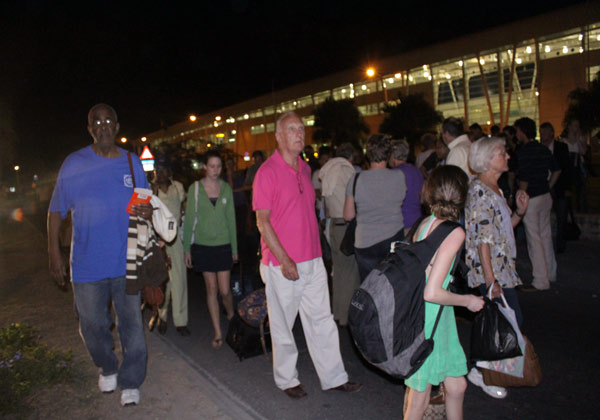 Passengers standing alongside the road and parking lot. passengers19022010